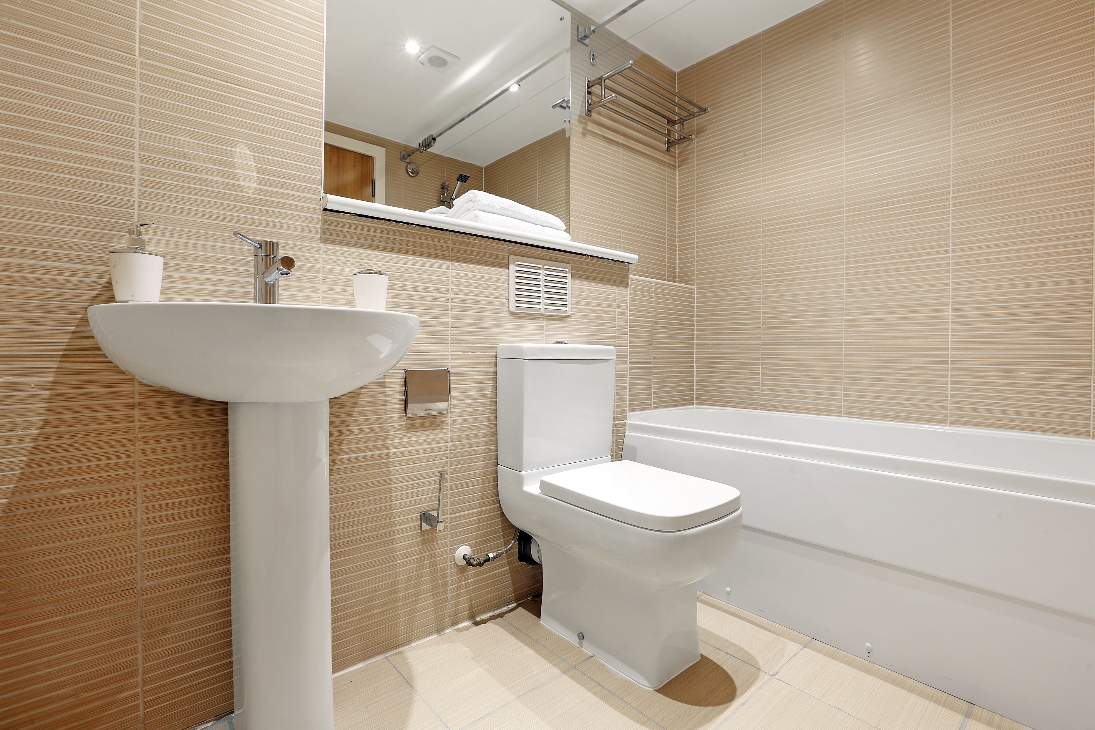 A modern bathroom with a sink, toilet, and bathtub.