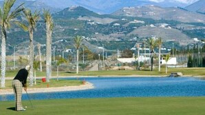 A golf course with a view of snow-capped mountains in the background. - Nuevo Tropical (Motril)
