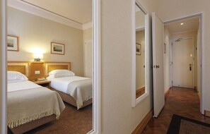 A hotel room with two beds, a nightstand, a lamp, and a mirror. - Hotel Lisboa Plaza (Lisbon)