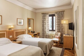 A hotel room with two beds, a desk, a chair, a TV, and a window with curtains. - Hotel Lisboa Plaza (Lisbon)