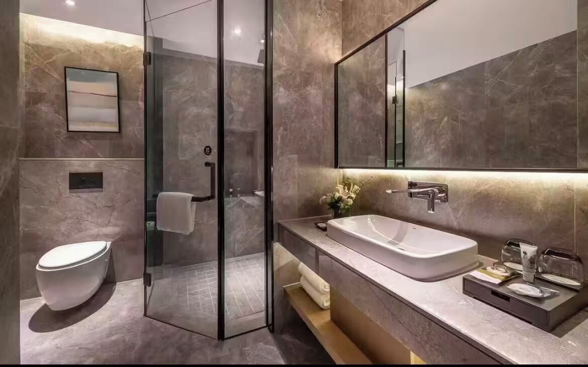 Un baño moderno con cabina de ducha de vidrio, un lavabo blanco y un espejo grande.
