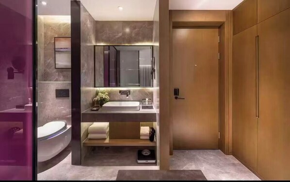 A modern bathroom with a vanity, sink, mirror, and a toilet. - Mercure Kunshan MIXC Hi-tech (Suzhou)