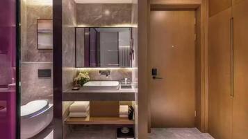 Un baño moderno con lavamanos integrado, espejo y ducha.