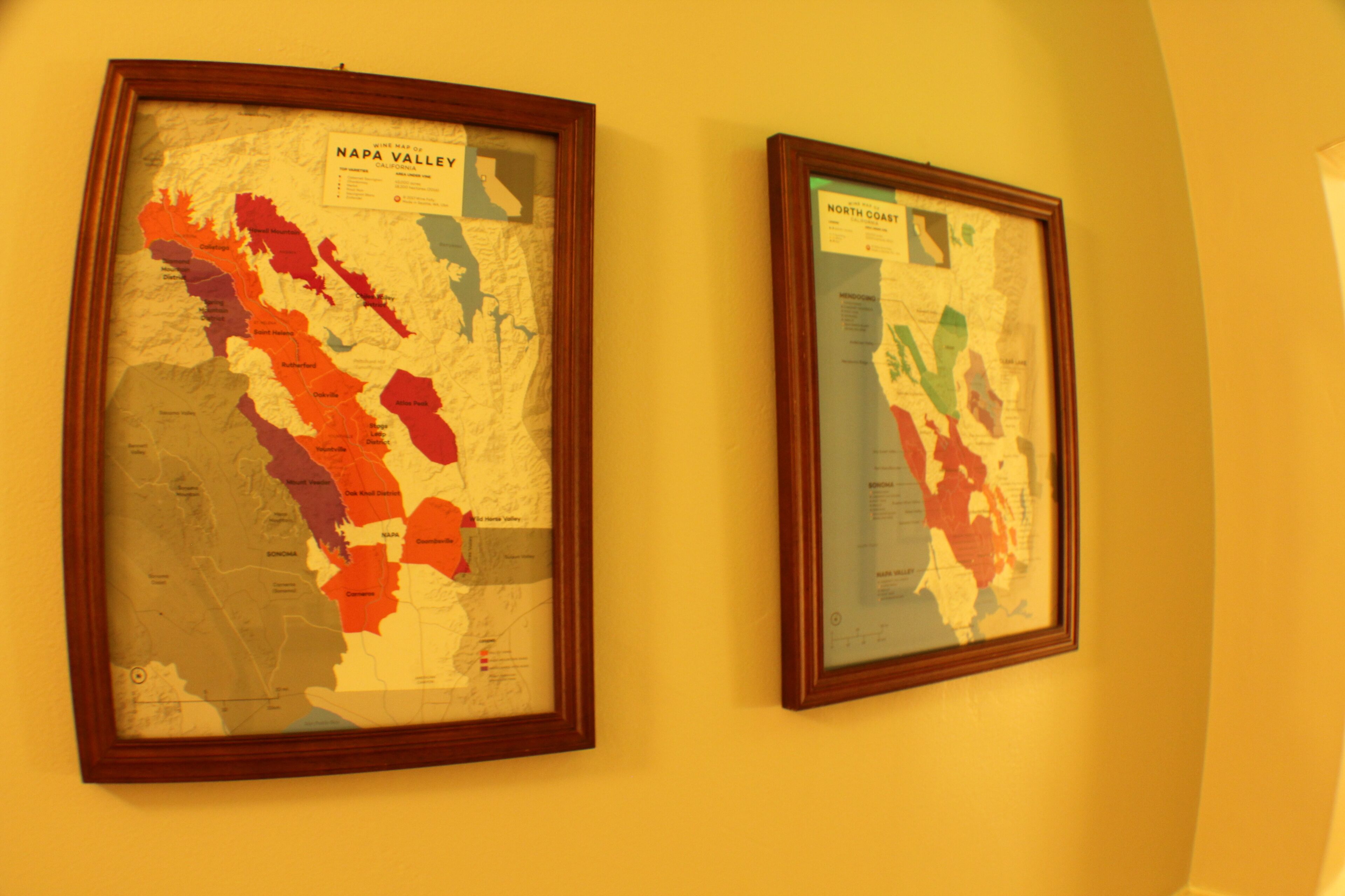 Two framed maps of Napa Valley and North Coast on a wall.