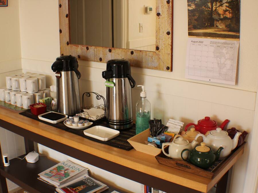 Una barra de desayuno con cafeteras, teteras y un calendario en la pared.