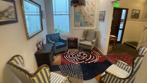 A lobby with striped chairs, a blue armchair, a map on the wall, and a red carpet. - San Anselmo Inn (San Anselmo)