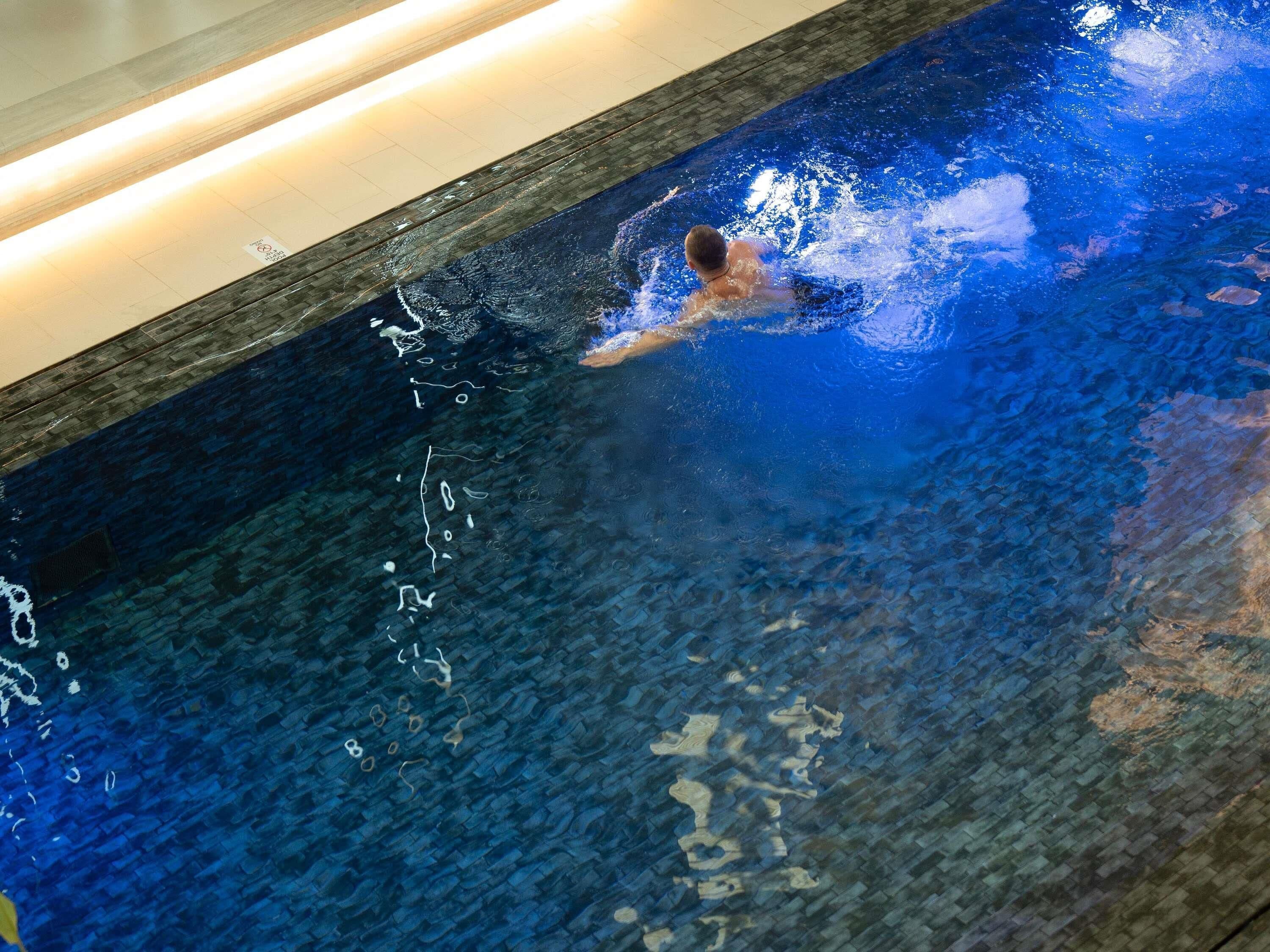 A swimming pool with clear water and a swimmer.