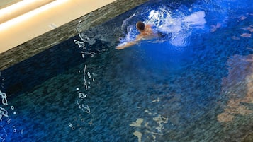 A swimming pool with clear water and a swimmer.