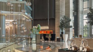 A modern lobby with a glass staircase, a reception desk, and a coffee station. - Fairmont Riyadh (Riyadh)