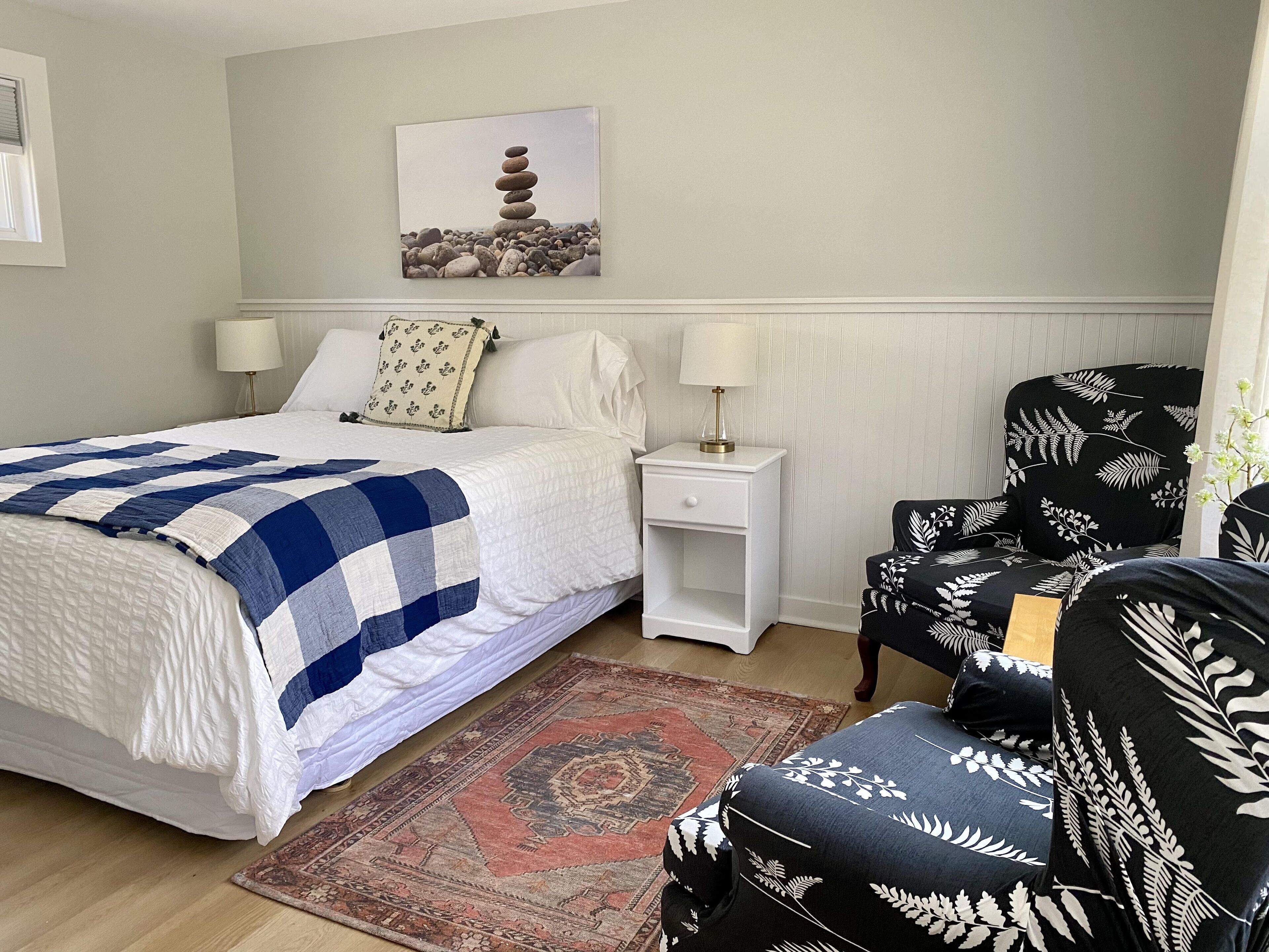A bedroom with a bed, nightstands, a chair, and a rug.