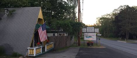 A roadside motel with a small American flag display, signs for 'Hanscom's Motel & Cottages' and 'Pets Welcome'.