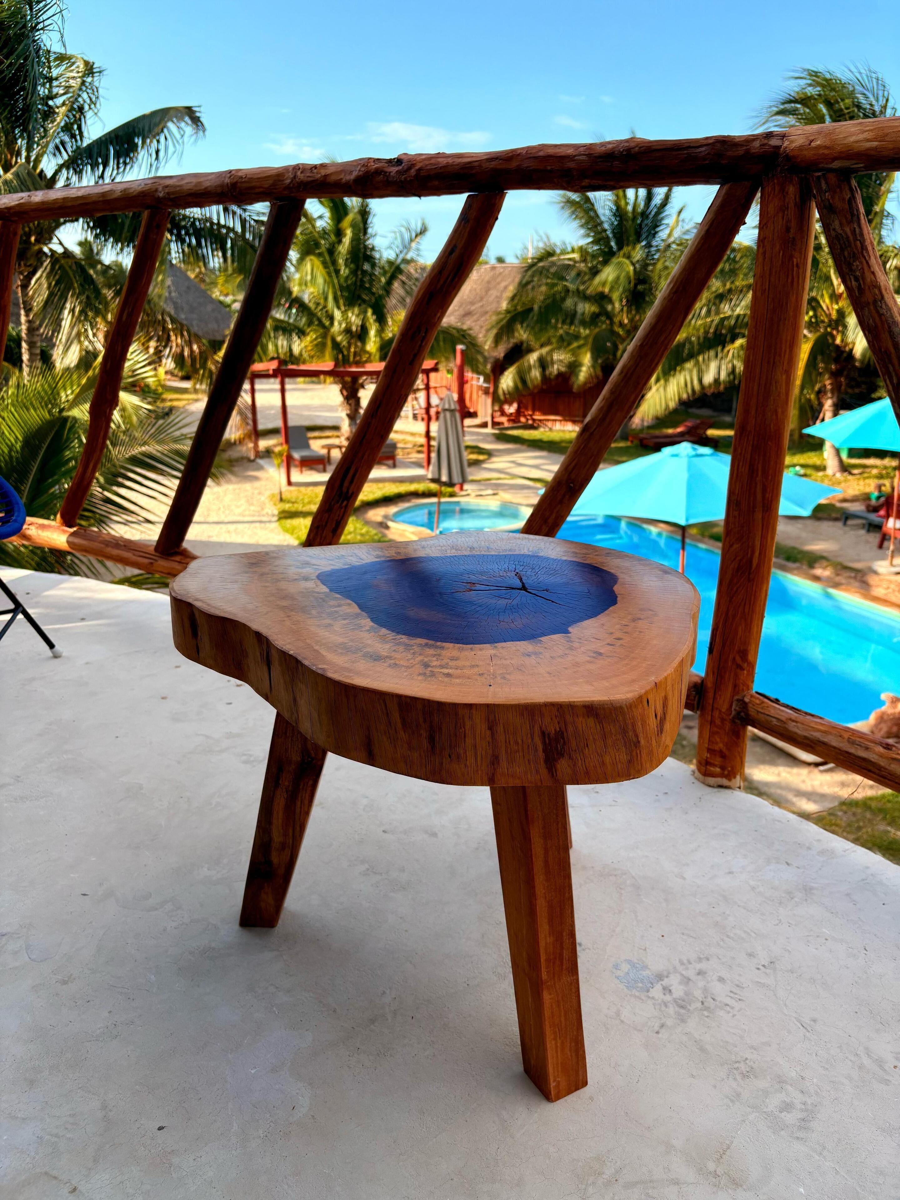 Una mesa de madera con un corte circular en el centro, sobre una superficie de concreto.