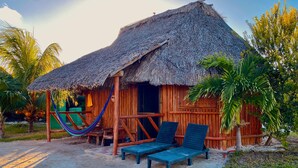 A thatched-roof hut with two lounge chairs and a hammock. - Jáalk'ab Cabañas (Progreso)