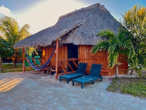 A thatched-roof hut with two lounge chairs and a hammock. - Jáalk'ab Cabañas (Progreso)