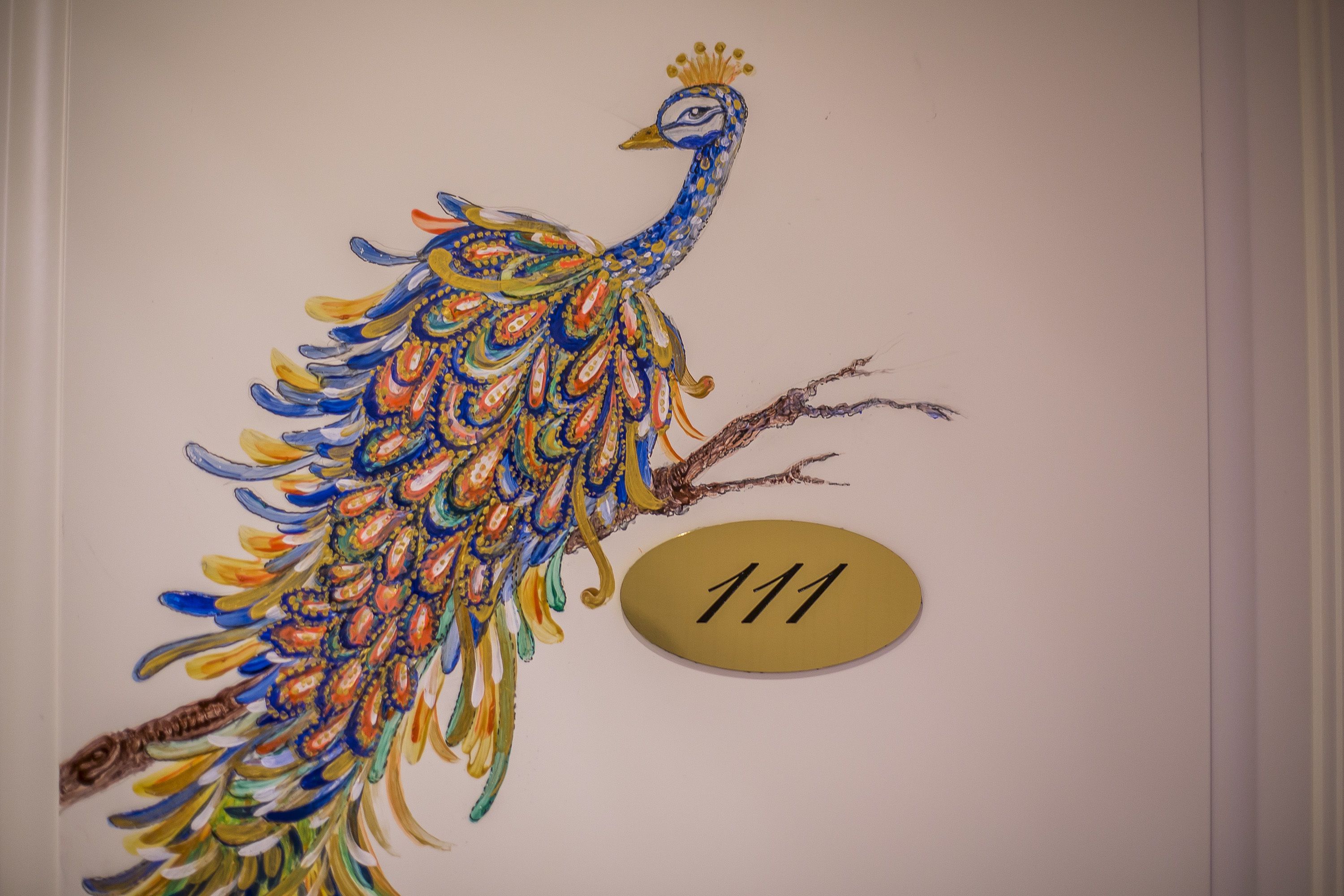 Ein Wandgemälde mit einem Pfau und der Zahl 111.