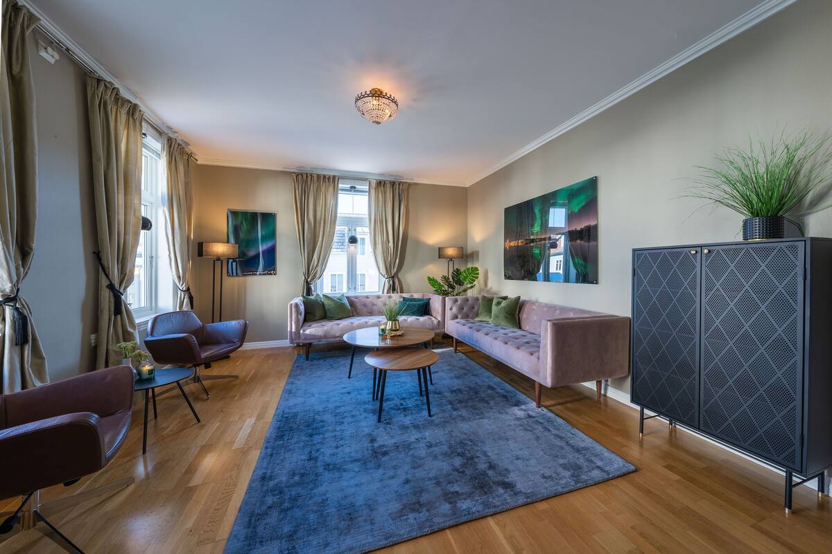A modern living room with a sofa, armchairs, a coffee table, and a large cabinet.