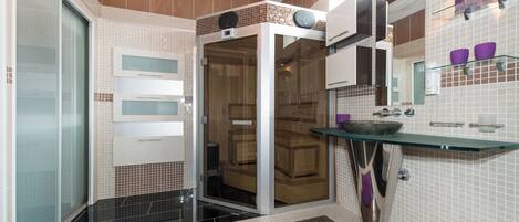 Une salle de bain moderne avec une douche à parois de verre, un lavabo en verre et un meuble-lavabo avec un miroir.