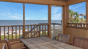 A wooden deck with a table and chairs overlooking a beach. - Gulf Front, Pet Friendly, N. Cape San Blas with Screened Deck ~ Whataday (Cape San Blas)