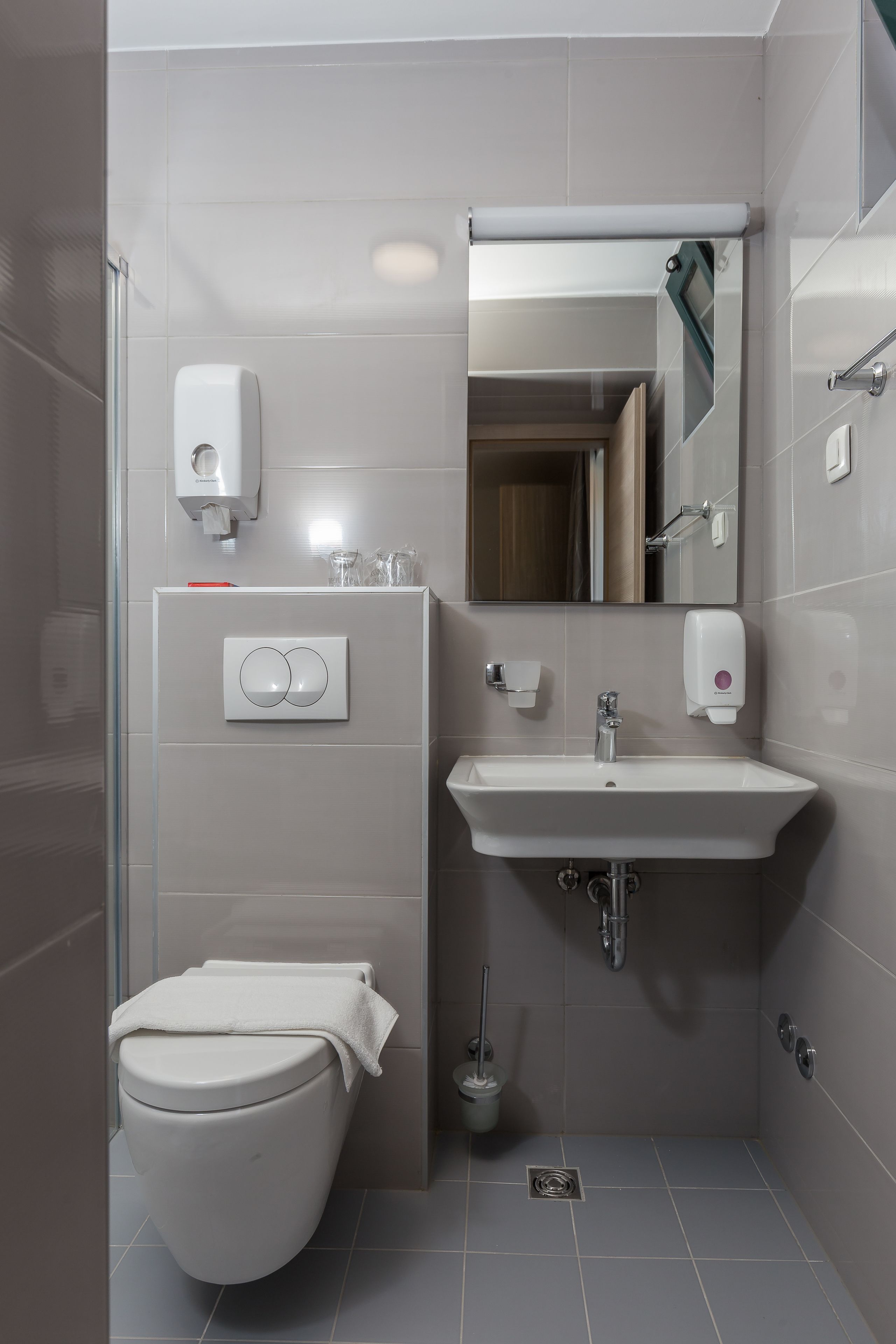 Ein modernes Badezimmer mit Toilette, Waschbecken und Handtrockner.