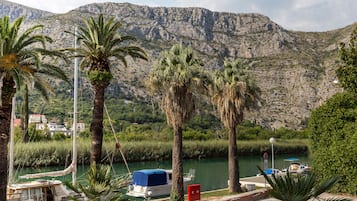 A boat docked near a river with mountains in the background.