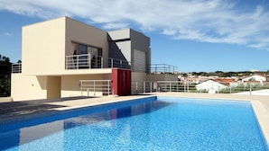 Un bâtiment moderne à deux étages avec une piscine à l’avant.