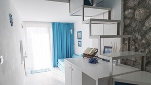 Een moderne, goed verlichte kamer met een wit bureau, een blauwe bank en een stenen muur.