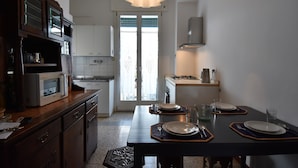 Una cocina moderna con una mesa de comedor para dos personas, un microondas y una cafetera.
