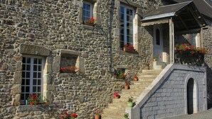 Un bâtiment en pierre doté de nombreuses fenêtres et de jardinières.