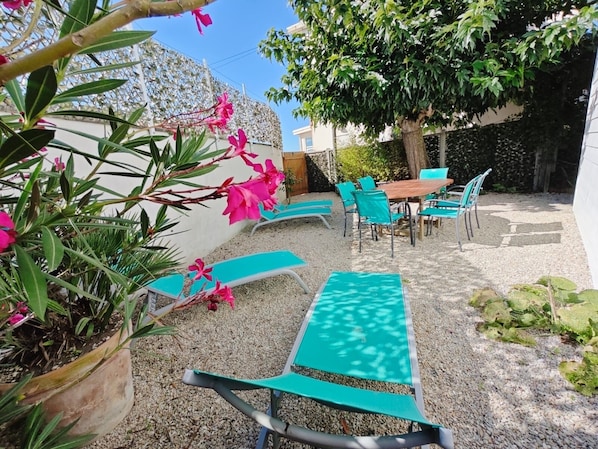 A patio area with outdoor seating, a table, and a potted plant.
