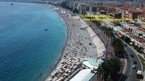 A coastal cityscape with a beach, buildings, and a road. - 2 bedroom, Overlooking Parc Exflora + Sea views. Pool+Beach 200m + Parking + A/C (Antibes)