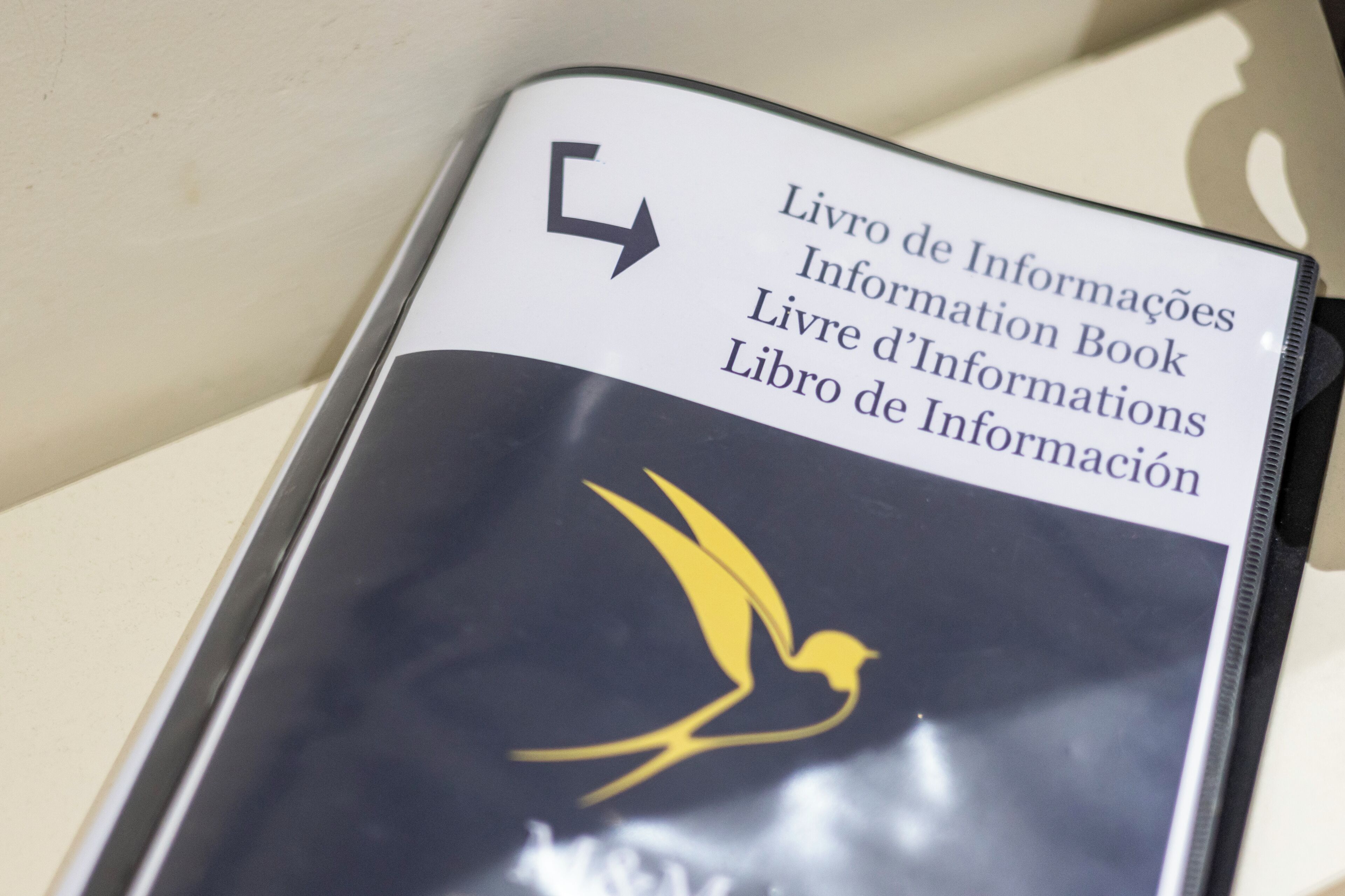 A book titled 'Livro de Informações' with a bird logo.