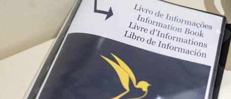 A book titled 'Livro de Informações' with a bird logo.