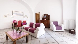 A living room with a white sofa, a white armchair, a wooden coffee table, and a bookshelf. - Vicaria, Sea View, a few steps from beach by AMALFIVACATION.IT (Minori)