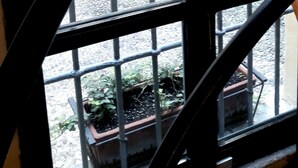 A window with metal bars and a view of a building with a yellow facade and a window with shutters. - Studio on two floors in an XVIII century building, just 500m from Duomo Square (Milano)