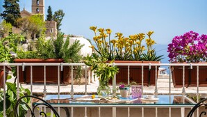 Une terrasse avec deux chaises en métal, une table et des plantes en pot.