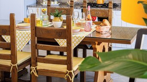 Une cuisine avec des chaises en bois, une table à manger et un luminaire suspendu.
