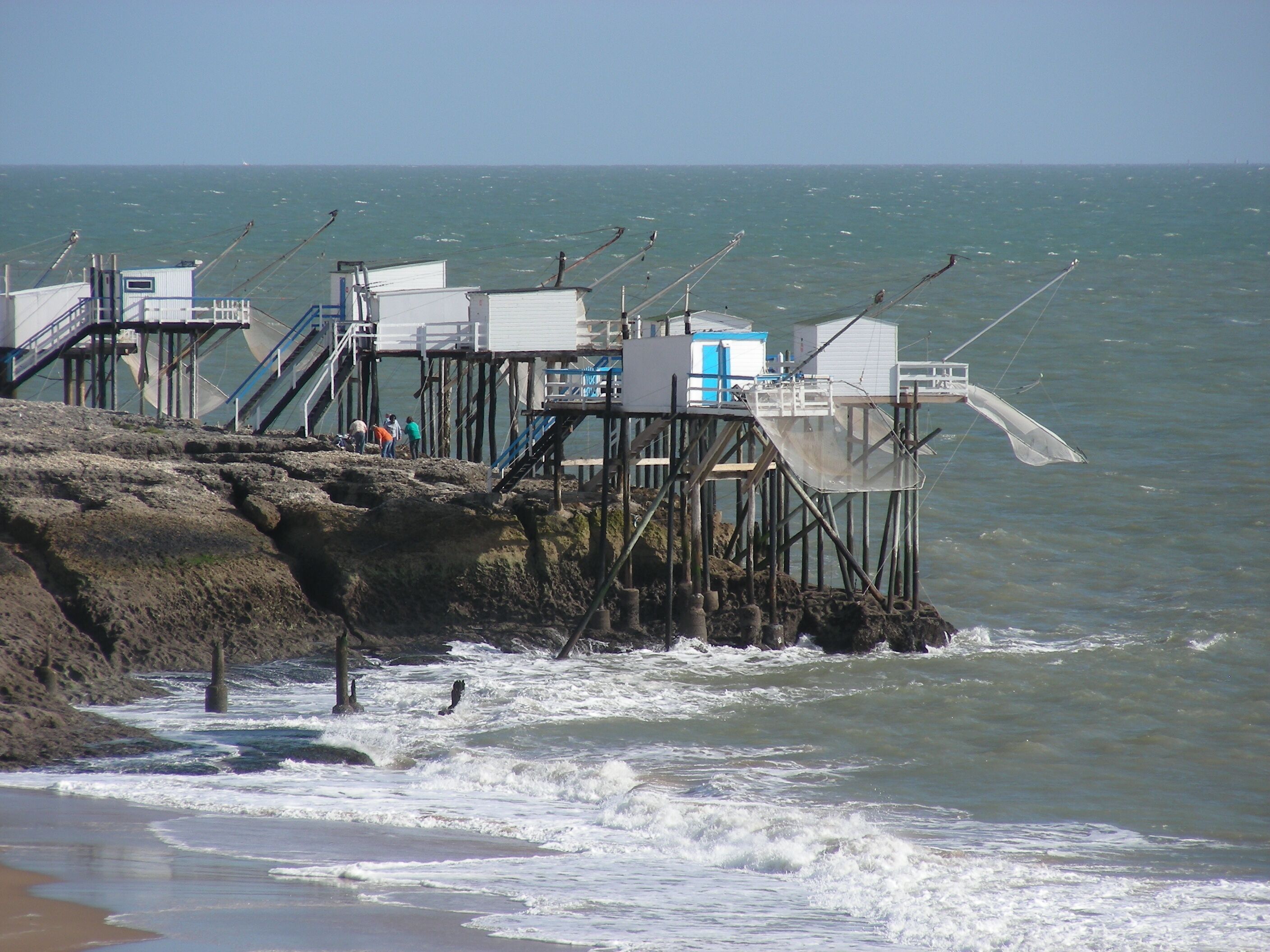 A pier with fishing huts and a staircase leading down to the water.