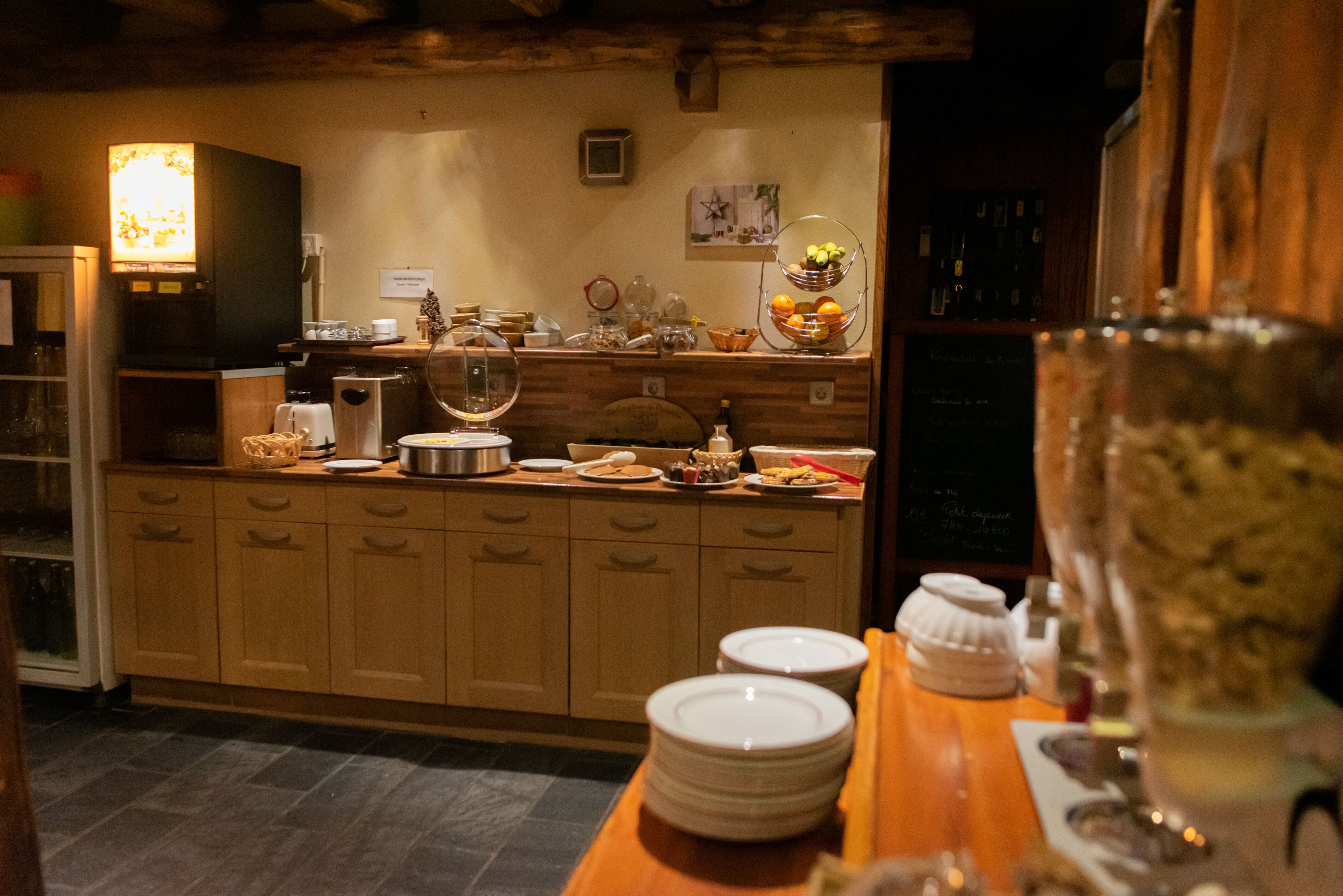 A kitchen with wooden cabinets, a coffee machine, and various kitchenware.