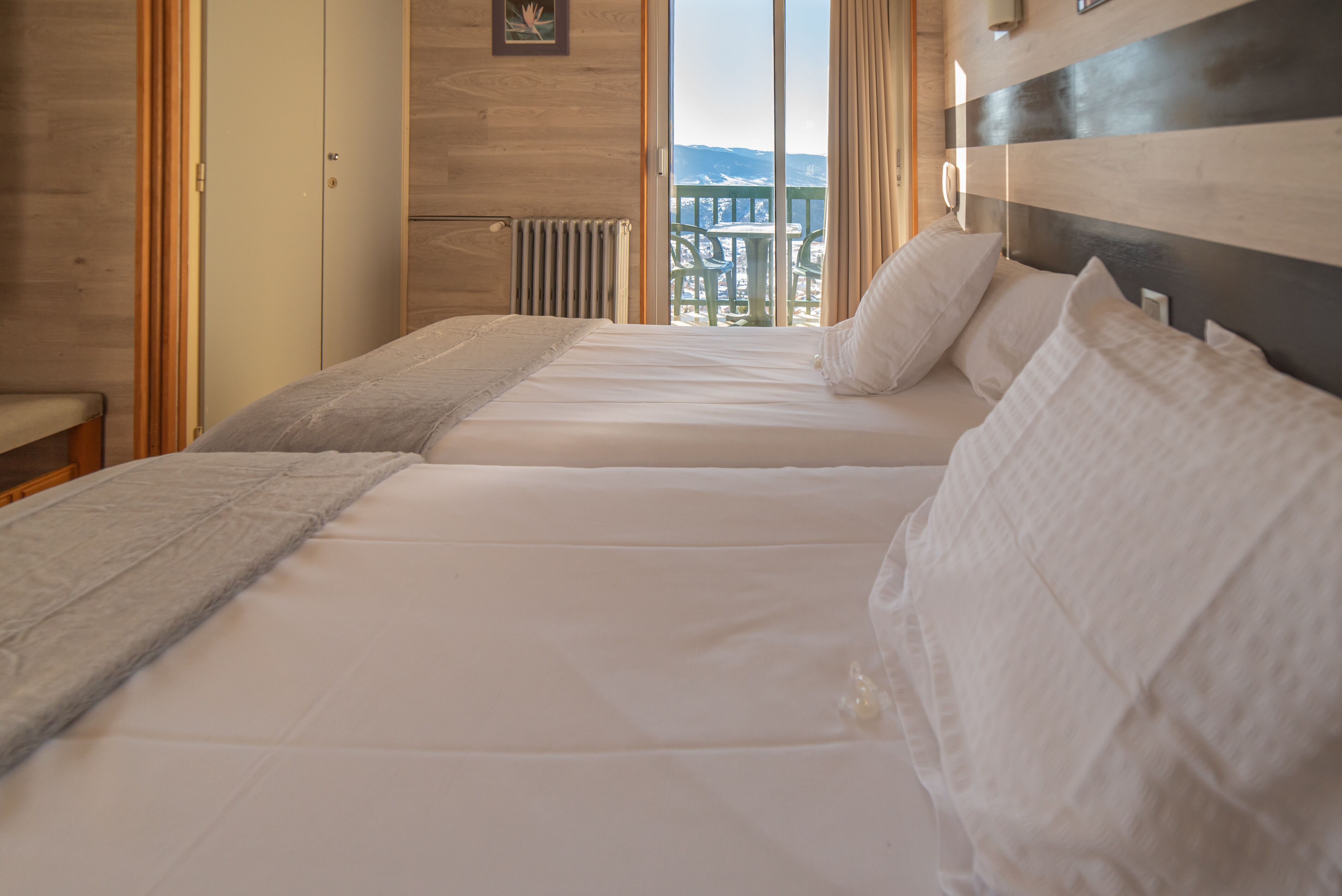 A room with a bed, a window, and a view of the outdoors.