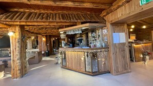 A rustic bar area with wooden beams and a bar counter. - Hôtel des Pyrénées (Font-Romeu-Odeillo-Via)