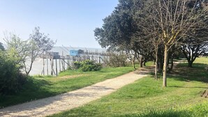 Un chemin de gravier mène à un quai, avec un bâtiment bleu en arrière-plan.