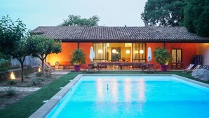 Ein modernes Haus mit Schwimmbad, Sitzgelegenheiten im Freien und einem Essbereich.