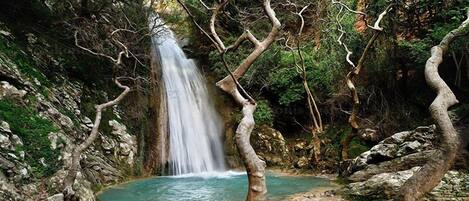 A waterfall surrounded by rocky terrain and trees.