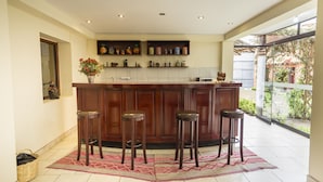 A kitchen with a central island, bar stools, and a view of the outdoors. - Yucay Plaza Inn (Yucay)