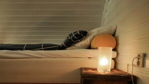 Habitació acollidora amb un llit, una taula petita amb una làmpada i un sofà.