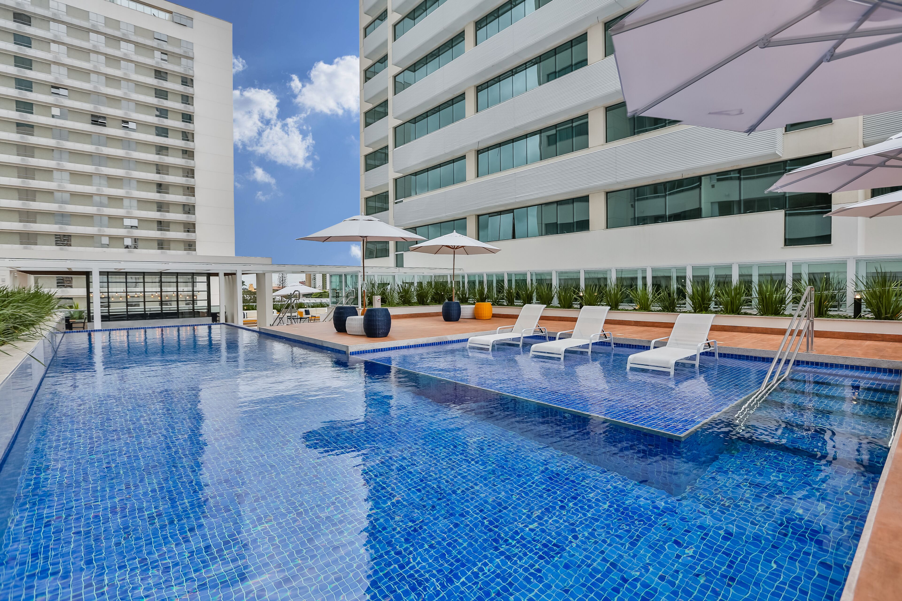 Una piscina al aire libre, sillones reclinables de piscina