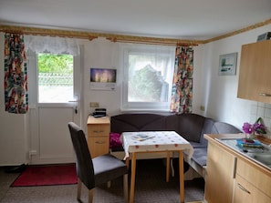 A small, cozy room with a single bed, a table with a polka dot tablecloth, a chair, a small cabinet, and a window with curtains. - Apartment - FW SPRC 0141 (Parchtitz)