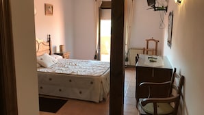 A bedroom with a bed, bedside table, and a desk with a chair. - Posada La Maza (Arnuero)