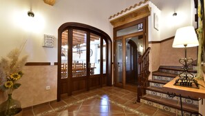 A spacious hallway with a wooden staircase, a wall-mounted light fixture, and a decorative vase with dried plants. - 44059 Sa Torre nova - 44059 S'Illot - Sa Torre nova (San Lorenzo)