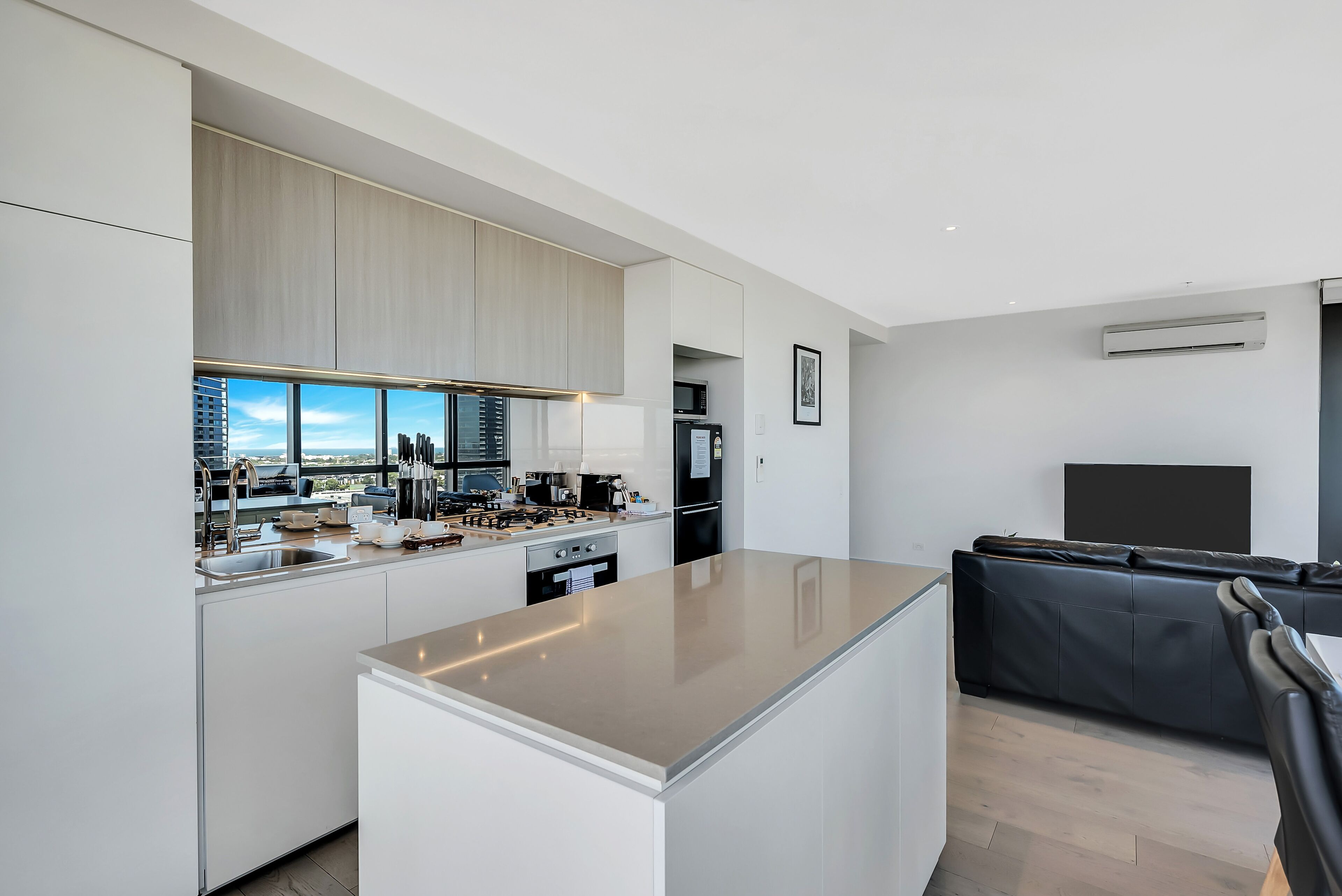 A modern kitchen with a central island, built-in appliances, and a city view.